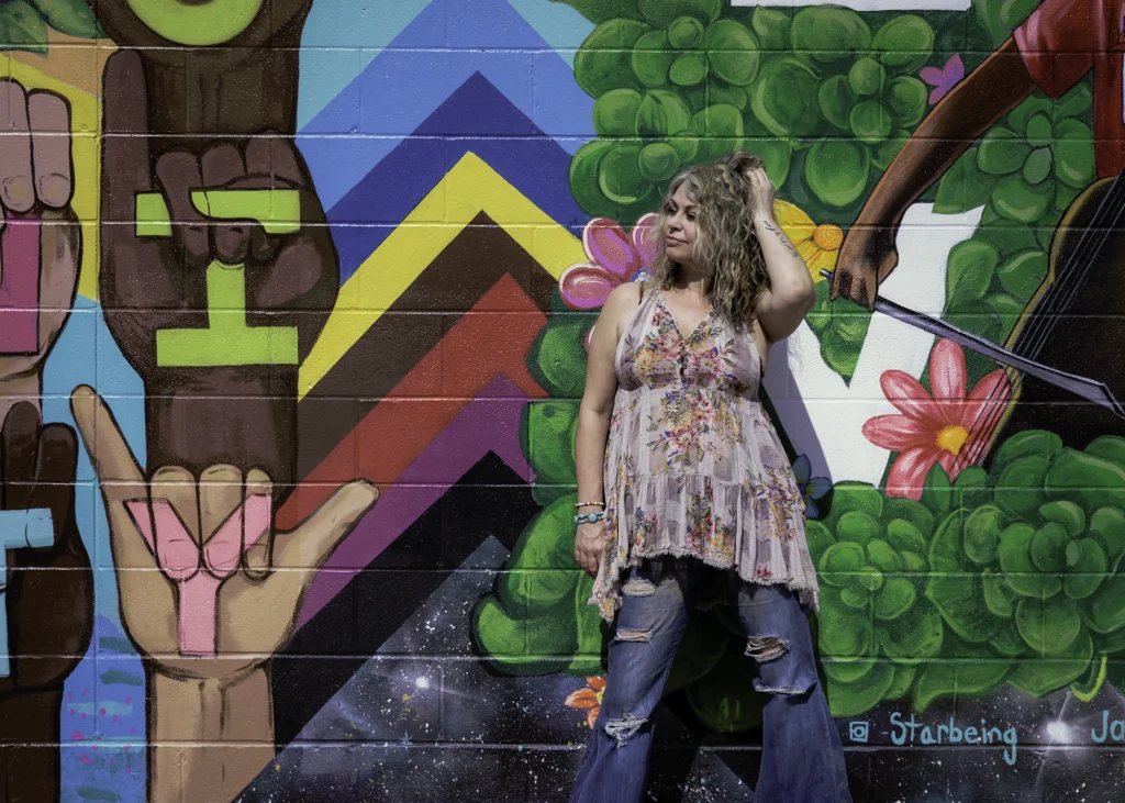 A client poses in front of the large parking lot mural in Oberlin, Ohio.