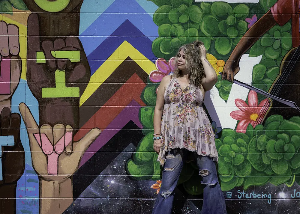 A client poses in front of the large parking lot mural in Oberlin, Ohio.